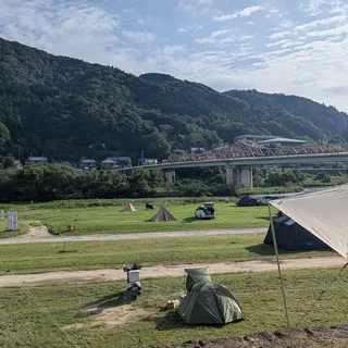 笠置キャンプ場の河川敷の芝生と橋、山の眺め
