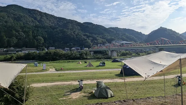 笠置キャンプ場の河川敷の芝生と橋、山の眺め